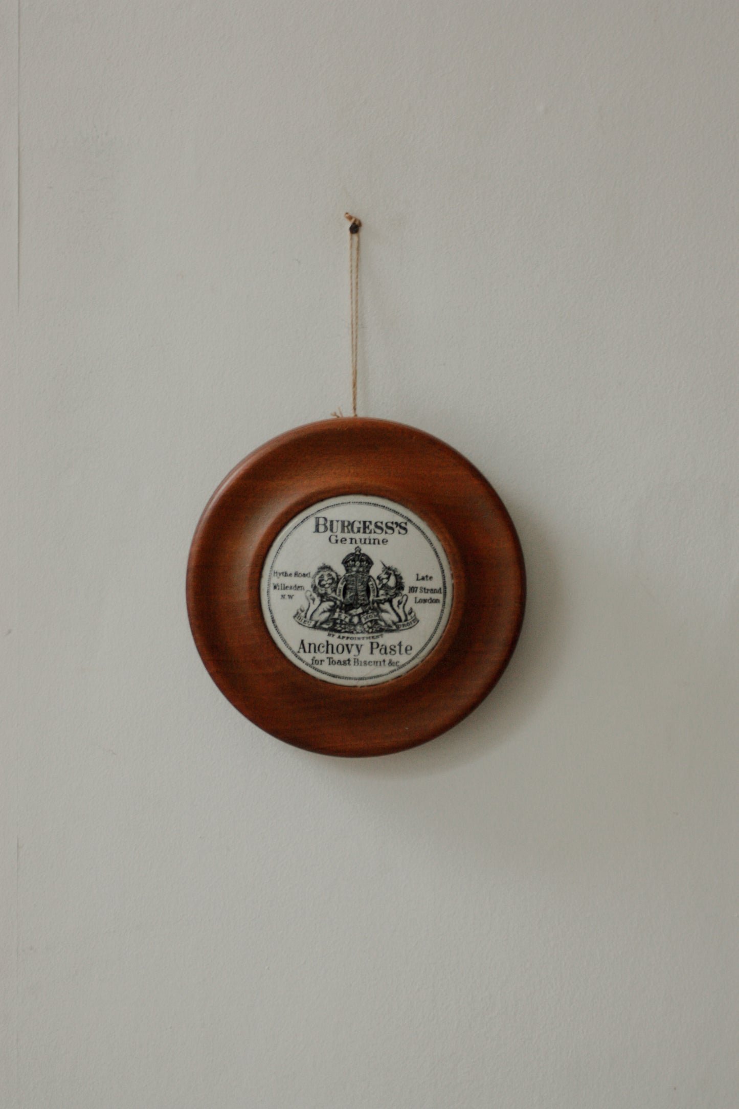 Vintage paste pot lid set in wooden frame