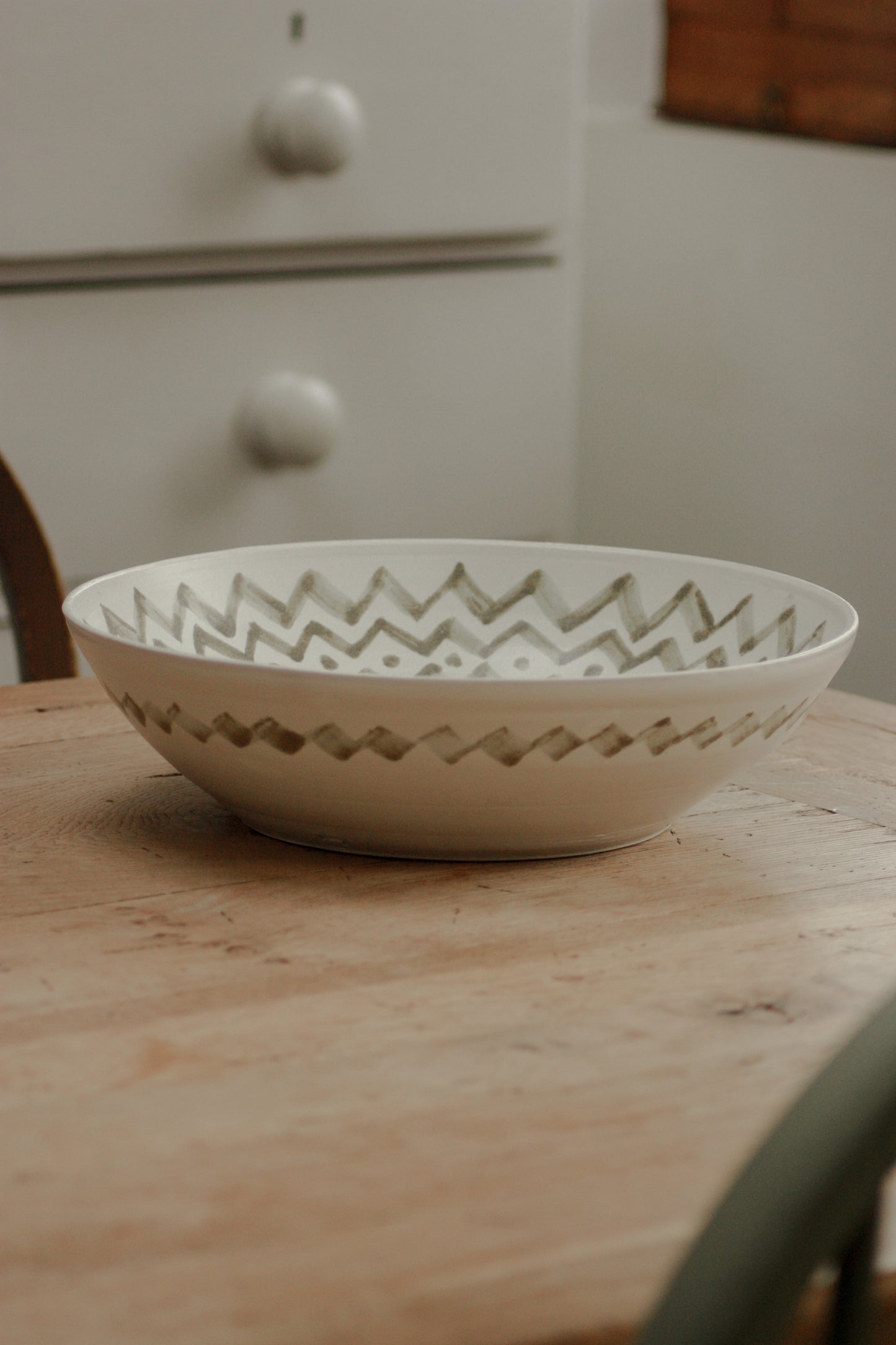 Large studio pottery serving bowl with muted green design