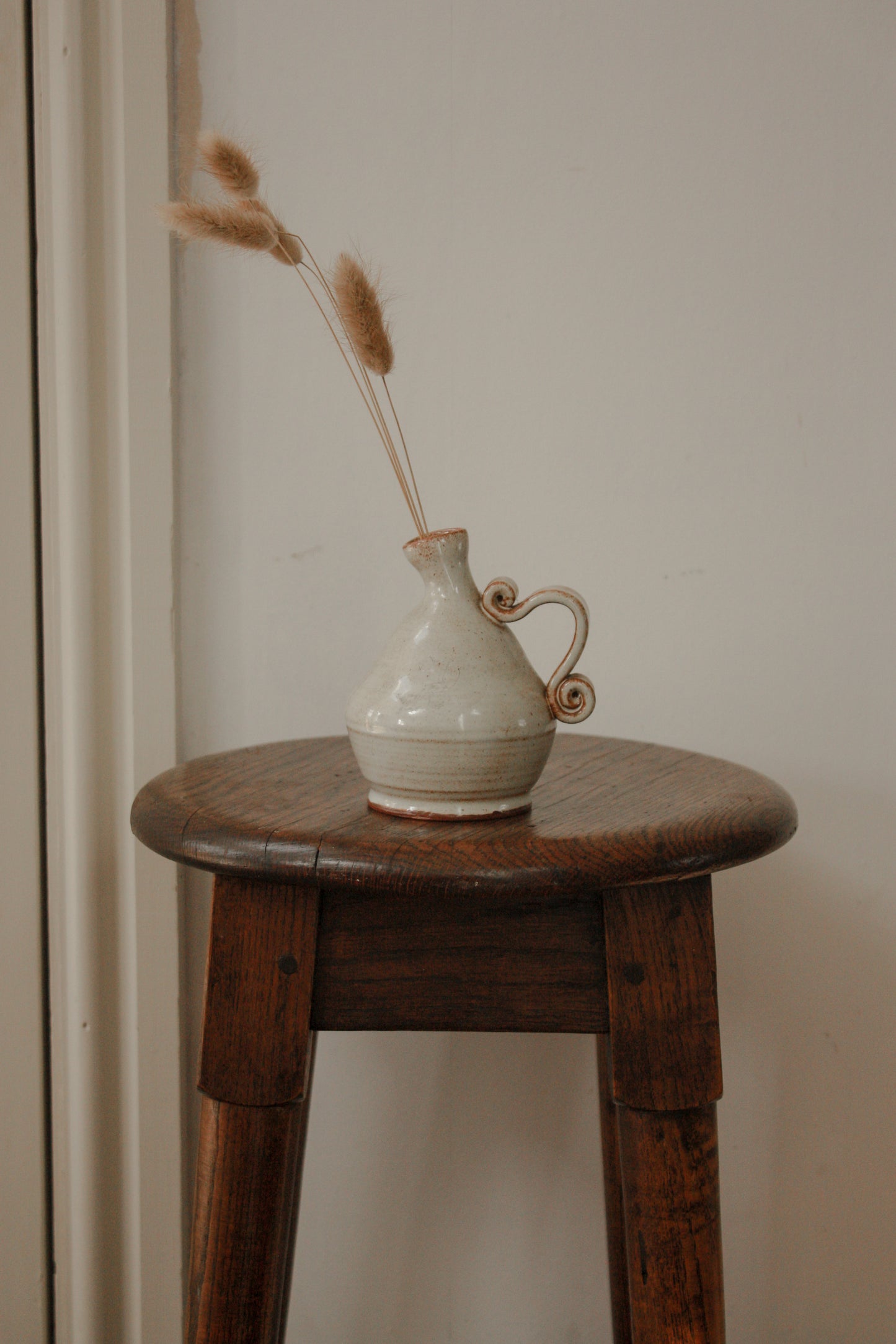 Studio pottery bud vase with scroll handle