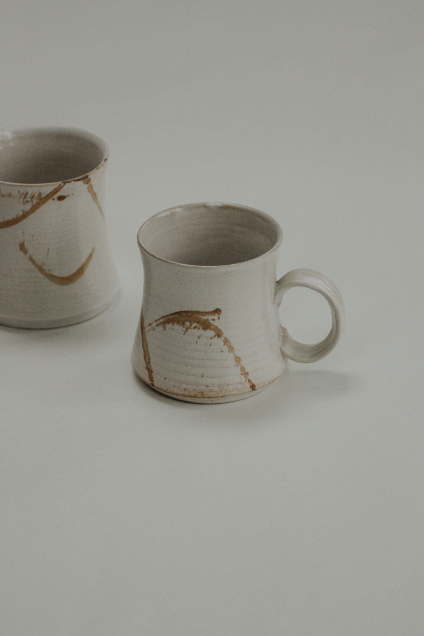 Pair vintage studio pottery mugs with neutral abstract design