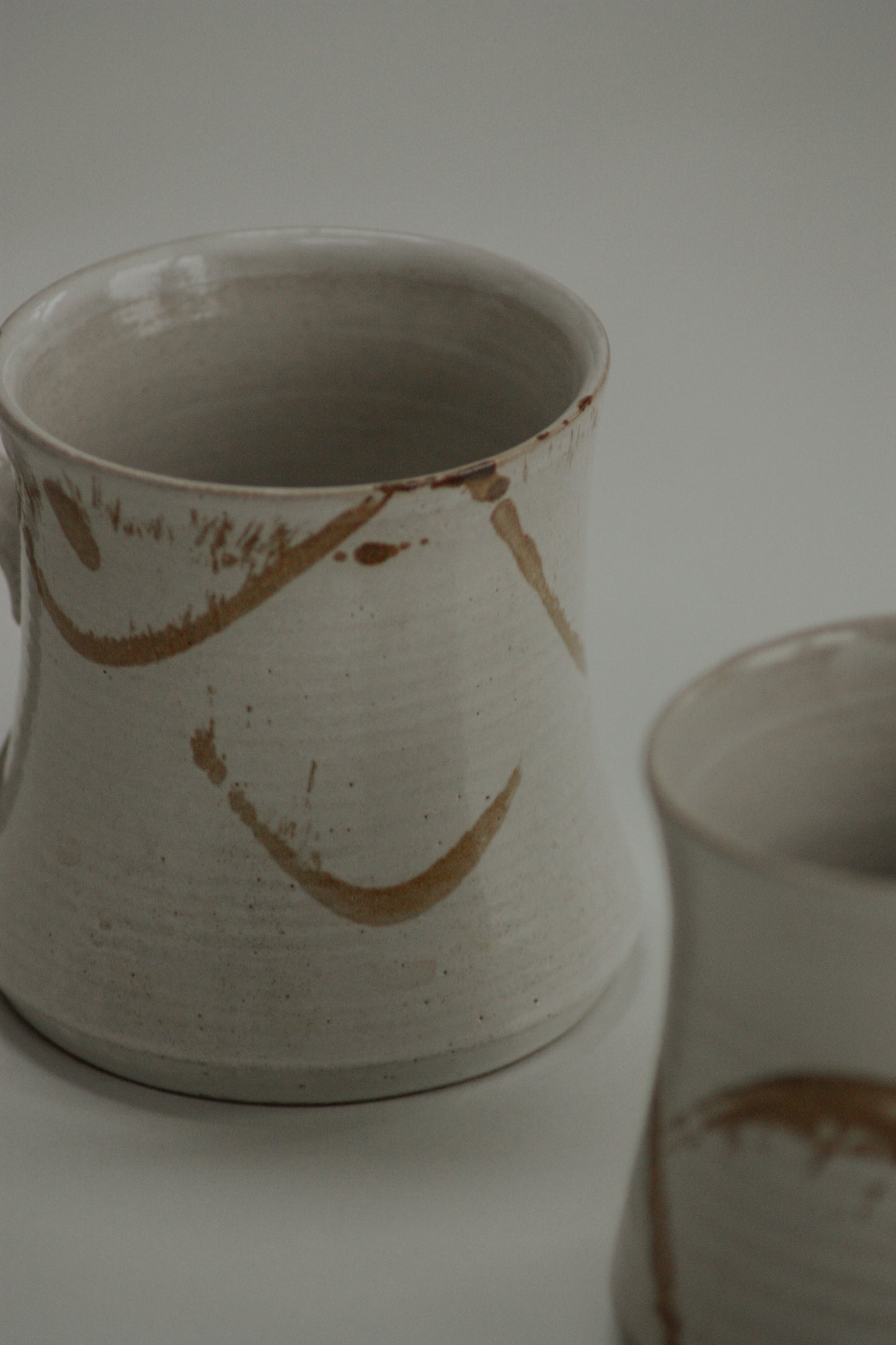 Pair vintage studio pottery mugs with neutral abstract design