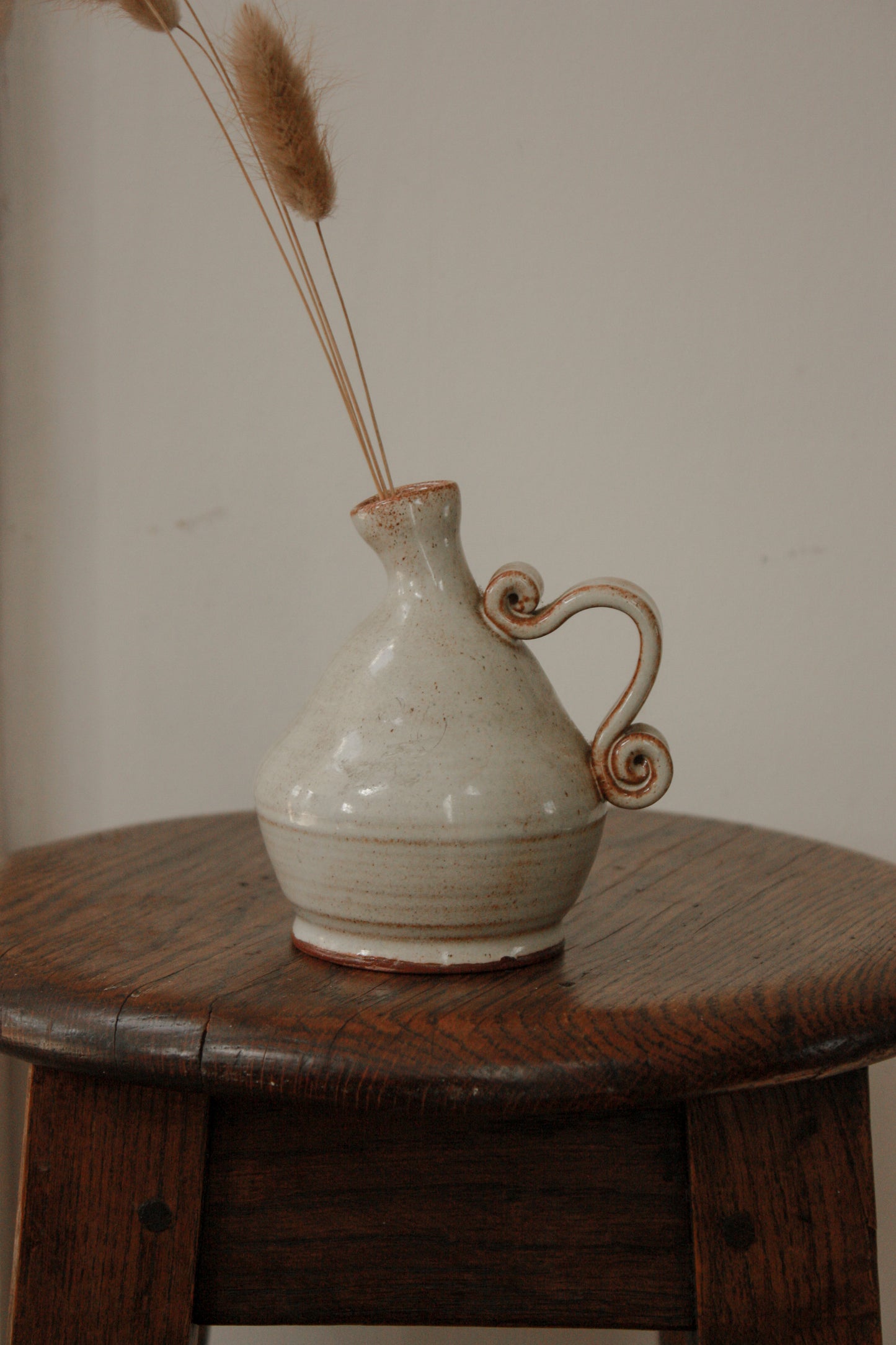 Studio pottery bud vase with scroll handle