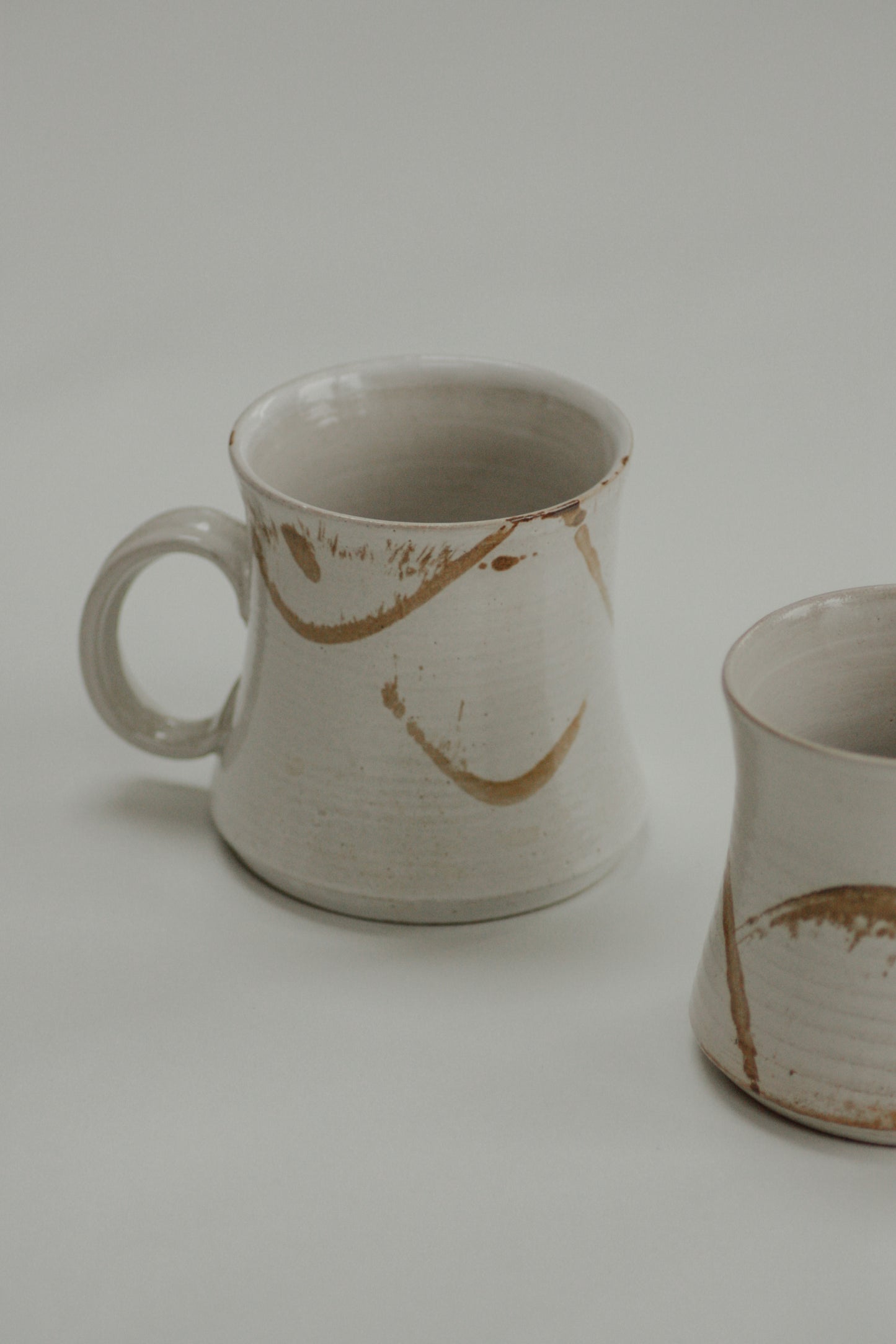 Pair vintage studio pottery mugs with neutral abstract design