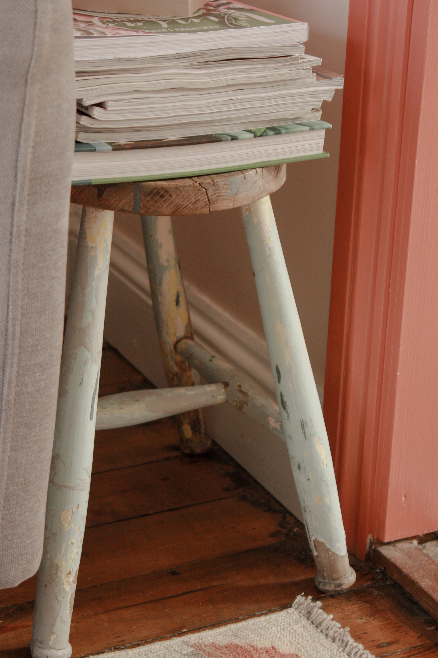 Vintage wooden stool with chippy blue painted legs