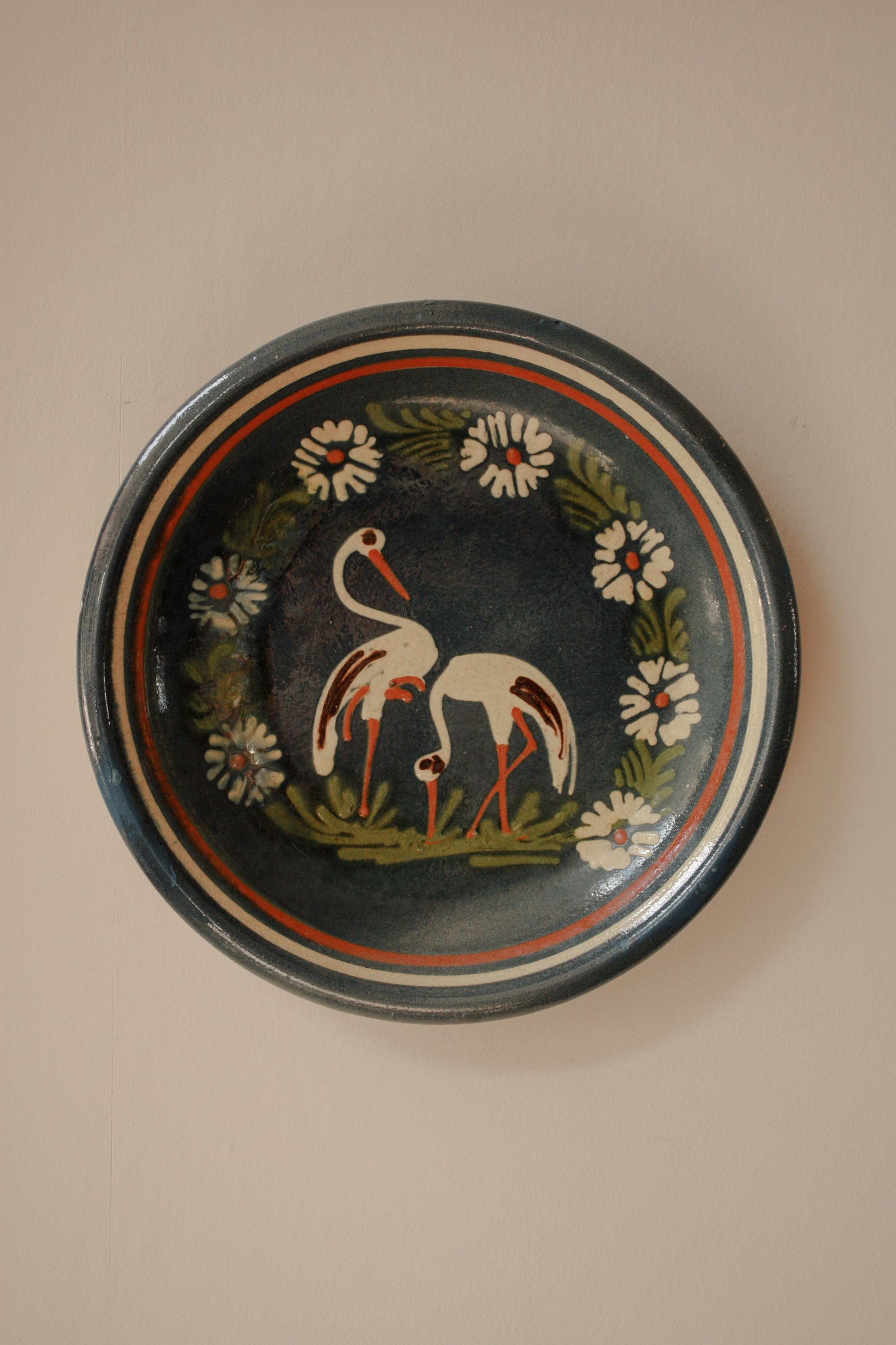 Large art pottery slipware wall plate - storks and flowers
